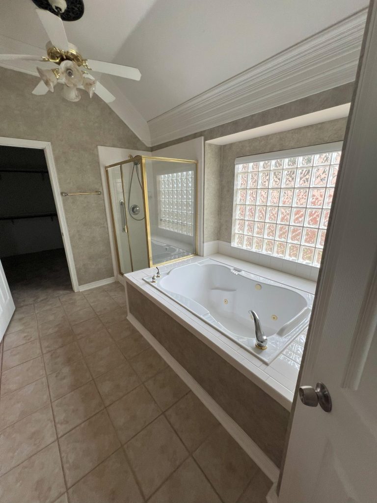 Dated master bath with tile and glass block